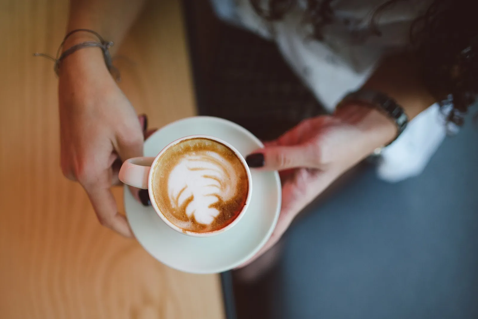 A cappuccino with latte art on a cafe table. The photo was not taken in Savannah.