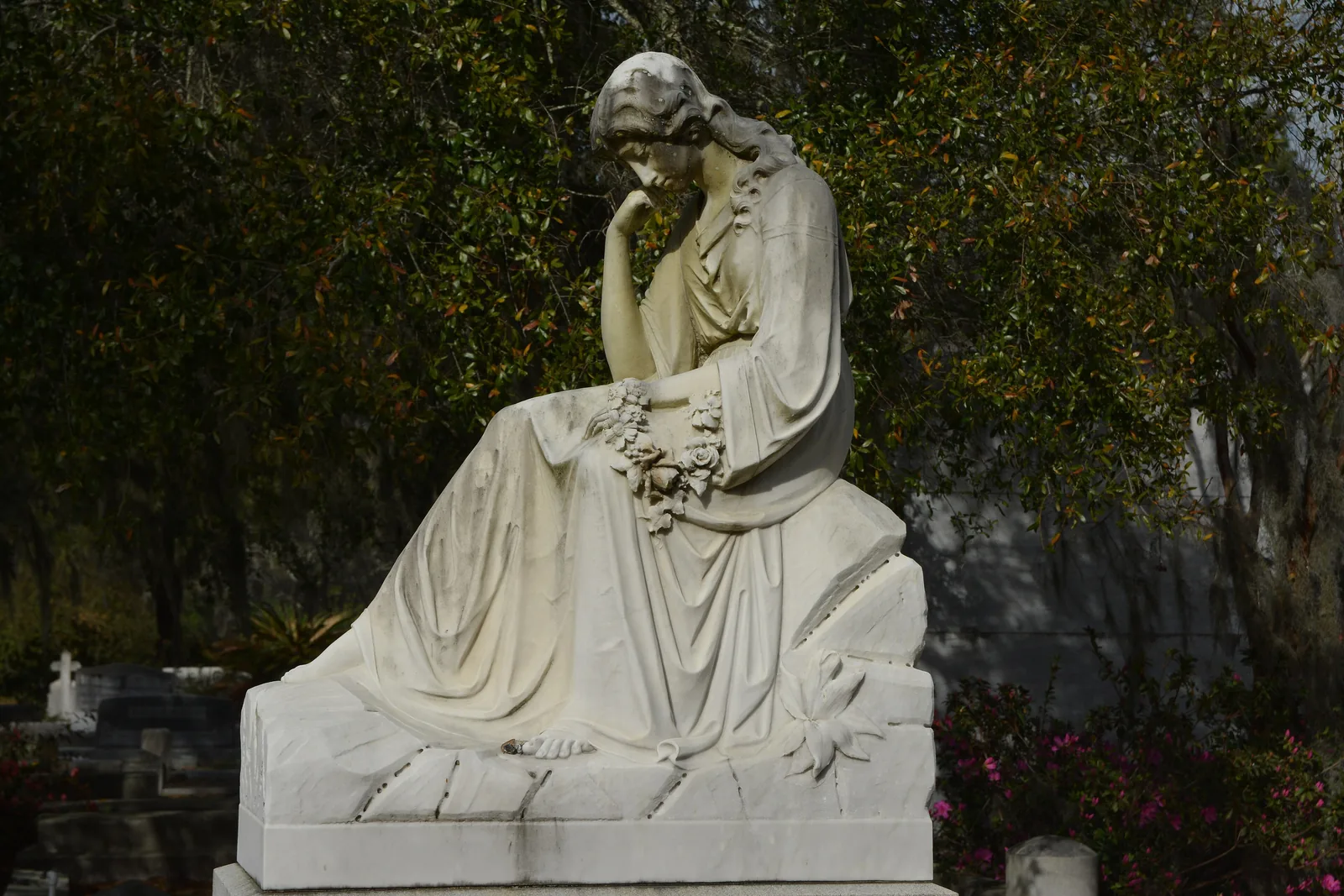 A marble mourning figure among the azaleas at Bonaventure Cemetery, which is free to visit daily.