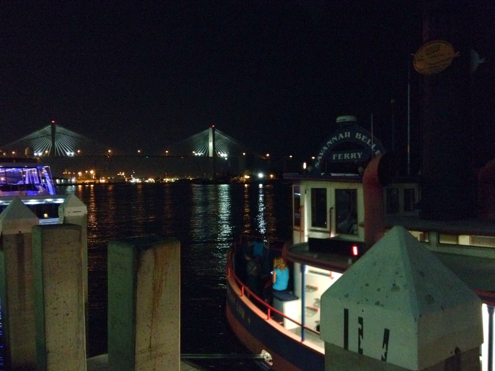 The Talmadge Memorial Bridge lit up at night, seen from the River Street dock of the Savannah Belles Ferry.