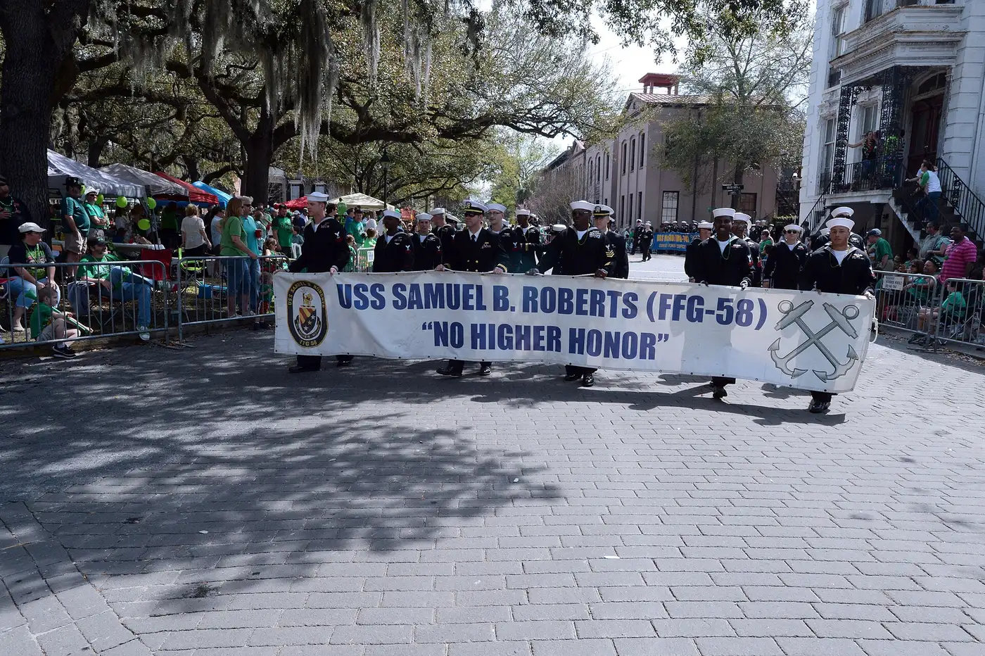 Sailors march past green-clad crowds behind the barricades in Savannah's St. Patrick's Day Parade.